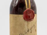 an old bottle of liquor with a wax seal on it