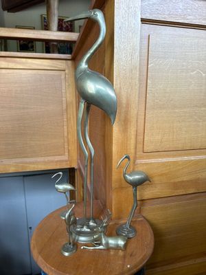 une statue métallique représentant un oiseau, posée sur une table en bois