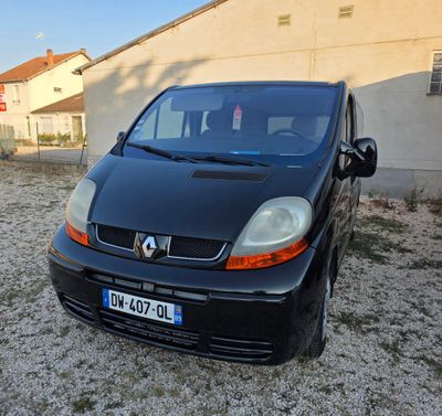 a small black car parked in front of a building
