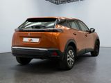 the rear end of an orange car parked in a garage