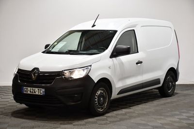 la camionnette blanche est garée dans une pièce au sol en damier