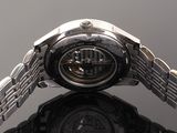a close up of a watch with a reflection on a table