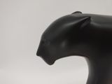 a black sculpture of a cat on a white surface