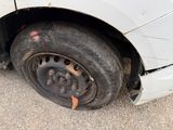 a white car that has a flat tire on it