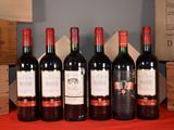 six bottles of red wine are lined up on a table