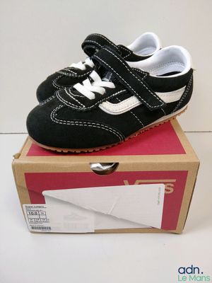 une chaussure de bébé noire et blanche posée sur une boîte