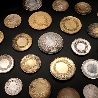 de nombreux plats en or et en argent posés sur une table noire