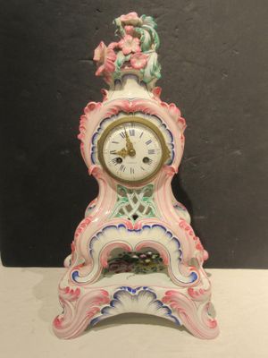 une horloge rose et blanche posée sur une table blanche