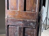a tall wooden cabinet with two doors on top of it