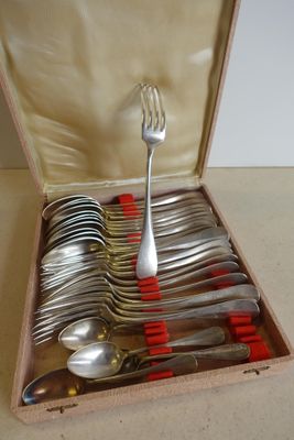 des couverts rangés dans une boîte en bois munie de poignées rouges et contenant des cuillères