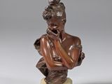 a bronze bust of a woman with her hand on her chin