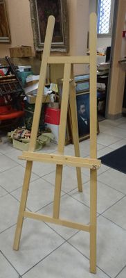 un chevalet en bois posé par terre dans une pièce