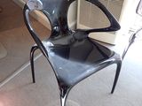une chaise en plastique noire posée dans un coin d'une pièce