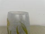 a glass vase sitting on a table with flowers painted on it