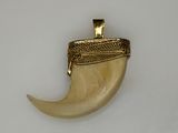 a gold plated pendant with a horn shaped object on it