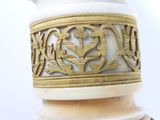 a white vase with a gold design on it