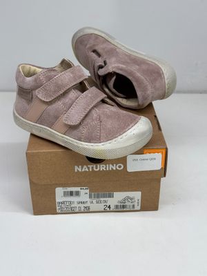 des chaussures de bébé dans une boîte posée sur une surface blanche