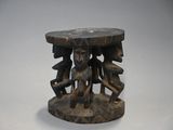 une petite table en bois dont le plateau est orné d'un motif sculpté