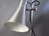 a silver lamp that is on a stand with a black cord