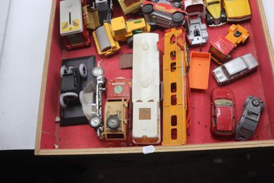 de nombreuses petites voitures et camions dans une boîte posée sur une table