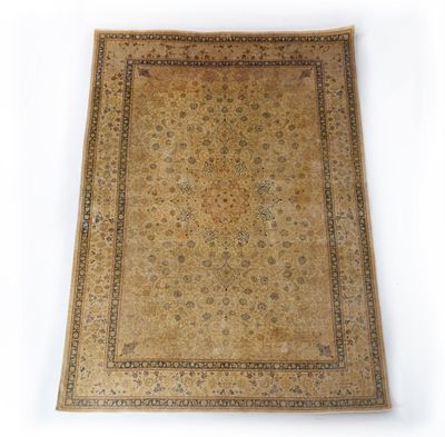 un tapis ancien à fond beige et bordure marron