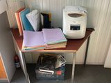 un petit bureau sur lequel se trouvent une imprimante et des livres