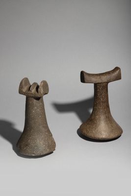 two pieces of pottery sitting next to each other on a white surface