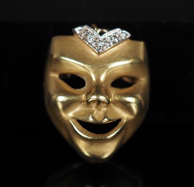 un gros plan d'un masque en or orné d'un diamant sur le dessus