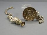 une pièce d'or et un bracelet en argent posés sur une table