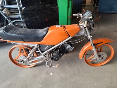 une moto orange et noire garée dans un garage