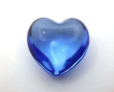 un cœur en verre bleu sur fond blanc