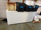a refrigerator that has many bins on top of it