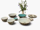 a vase with flowers in it next to a set of bowls and plates