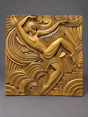 a gold sculpture of a woman sitting on top of a wave