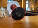 a red alarm clock sitting on top of a wooden table