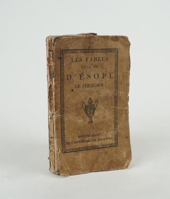 un vieux livre posé sur une table sur une surface blanche