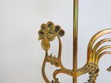 a gold rooster on a stand with a white background