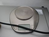 a silver electronic scale with a black cord on top of it