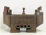 an old brass toothbrush holder with bottles on it