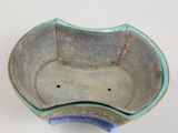 an image of a blue and green bowl on a white surface