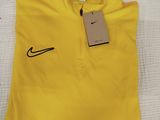 un polo Nike jaune avec une étiquette dessus