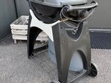 a grill that is sitting on a cart in front of a building