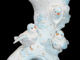 a white vase with birds on it on a black background