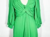 une robe verte posée sur un présentoir à mannequin, sur fond blanc