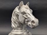 une statue représentant une tête de cheval posée sur un socle