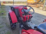 a red tractor that is parked on the side of the road