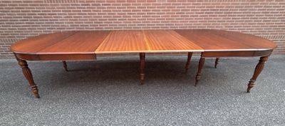 a large wooden table with two leaves on top of it