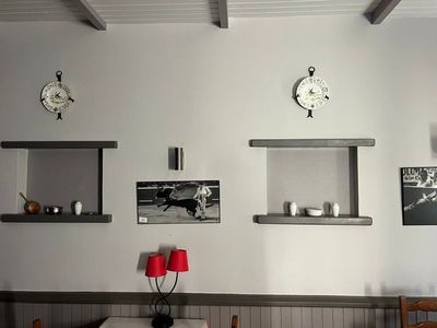 une salle à manger avec une table, des chaises et une horloge accrochée au mur