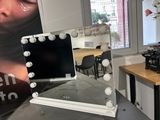 a vanity with a mirror and lights on it in a room