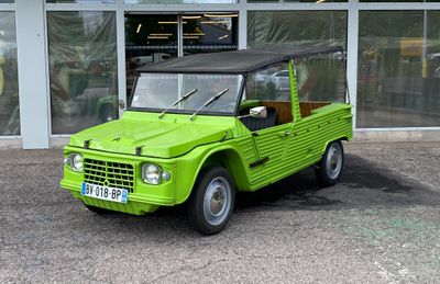 a green truck that is parked in front of a building